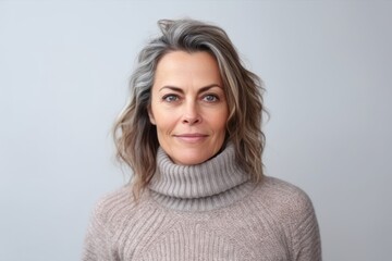 Close up portrait of a beautiful middle-aged woman with gray hair in a sweater on a white background