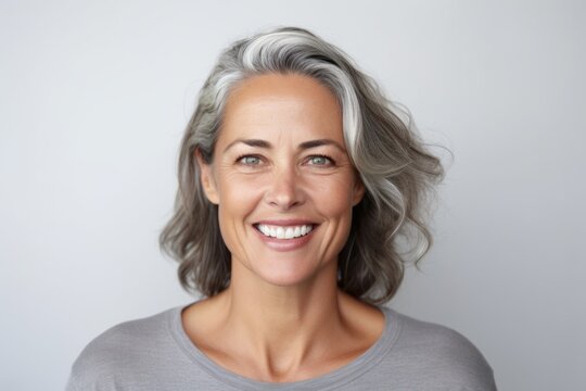Medium shot portrait photography of a grinning woman in her 40s that is placed against a white background . Generative AI