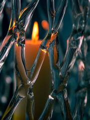 Burning orange candle in a glass mesh vase. Warm and cool color scheme. Abstract art.