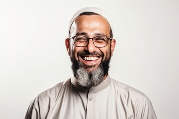 Portrait of a smiling muslim man with beard and glasses.