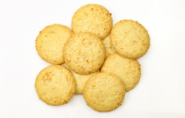 Pile of tea cookies with coconut isolated on white background. Delicious golden dessert pastry