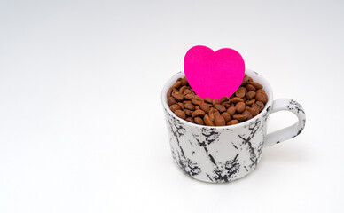 Cup of coffee beans and a pink heart