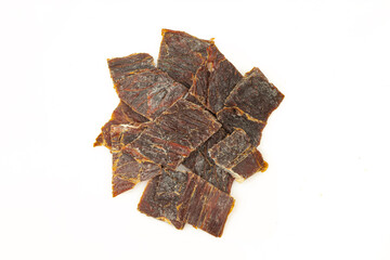 Stack of dry meat slices isolated on white background. Beef jerky pieces