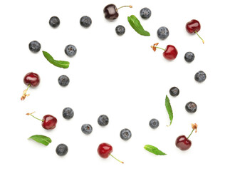 Frame made of ripe blueberry and cherry on white background