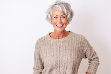 Lifestyle portrait photography of a pleased woman in her 70s that is wearing a cozy sweater against a white background . Generative AI