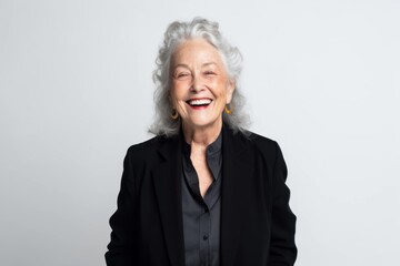 Portrait of smiling senior woman in black suit on white background.