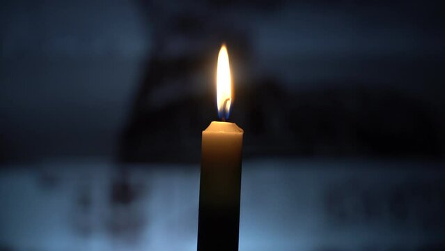 Burning candle on the table against the background of the yard