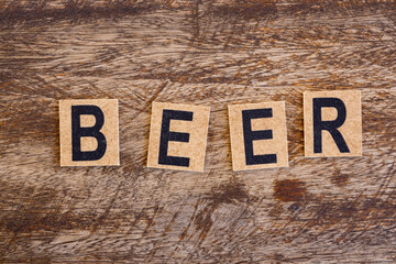 Fototapeta premium The word beer formed with wooden blocks on a rustic background.