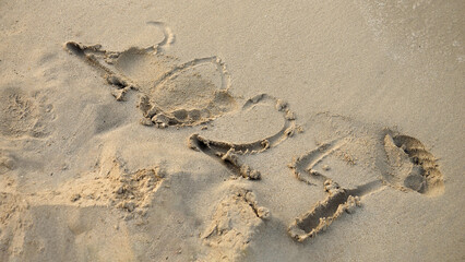 Closeup of female footprint over the 2024 year written on wet and at sea beach.