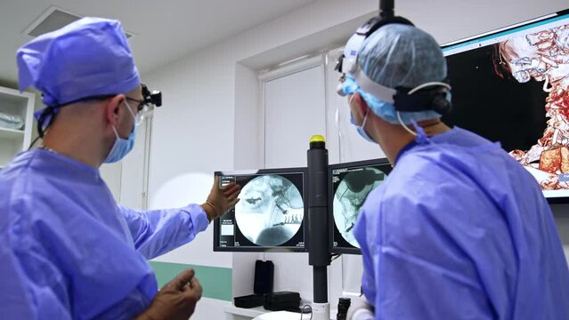 Surgeons look at the patient's x-ray scan and discuss the details of operation. Preparation for the neurosurgery.