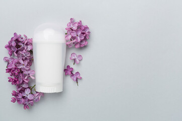 Composition with deodorant and flowers on color background, top view