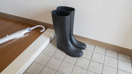 梅雨のイメージ｜玄関の長靴とビニール傘