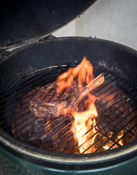 Ribeye steak grilling in the charcoal Green Egg grill.