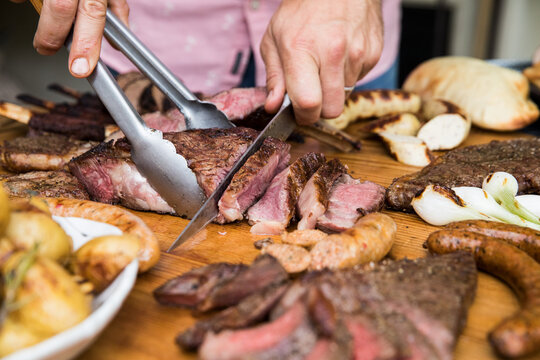 Person carving a ribeye steak.