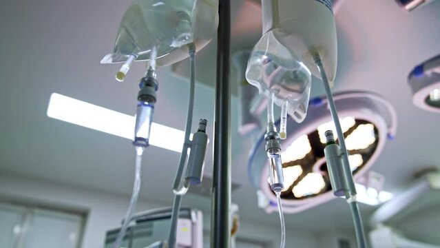 Drop counters hanging in the surgical room. Illumination equipment at backdrop. Low angle view.