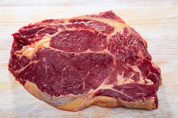 Close up of uncooked beef chop on wooden background