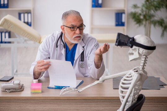 Old male doctor examining skeleton in the clinic