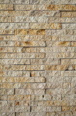 Textured Tan and Yellow Sandstone Brick Wall.