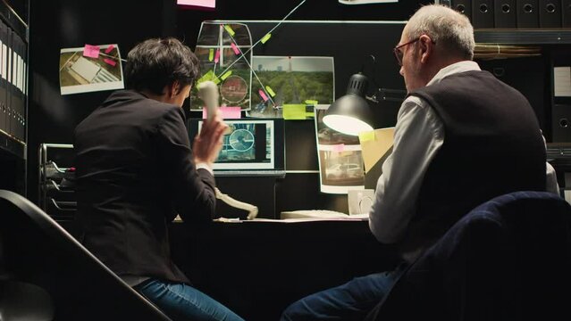 Detectives rushing to catch culprit, finding out about criminal whereabouts over office phone call. Team of inspectors running to capture killer suspect with incriminating proof. Handheld shot.