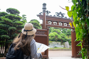 Asian tourist, cute woman with long hair are traveling in Hong Kong along with map and her camera with fun on her holiday, A temple in Hong Kong, concept travel.