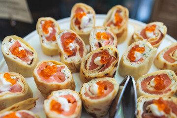 Catering table, beautifully decorated banquet with variety of with different food snacks appetizers on corporate birthday party event or wedding celebration, canape, salad, delicatessen setting
