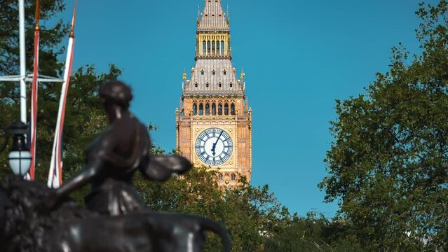 Big Ben clock tower on a sunny early morning in London, UK. A view of the popular London landmark, the clock tower known as Big Ben, showing 6pm as the time set against a blue and cloudy sky.