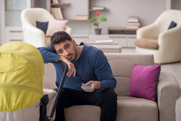 Young man looking after newborn at home