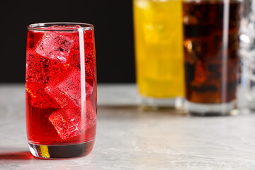 Glass of refreshing soda water with ice cubes on white table, closeup. Space for text
