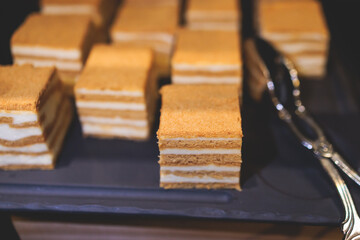 Beautiful multicolored decorated baked sweet tasty candy bar dessert on kids children party with happy people around, catering banquet table on kids children party