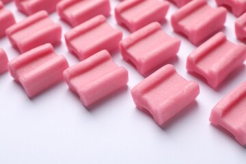 Tasty pink chewing gums on white background, closeup