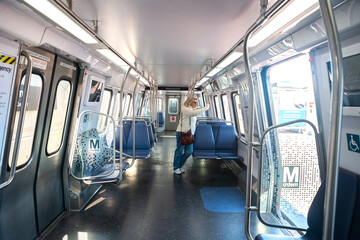 woman in an empty car on the Washington subway.