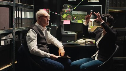 Detectives team reenacting crime scene with virtual reality glasses, using vr headset to recreate culprits actions for incriminating proof. Two police officers undertaking investigation.