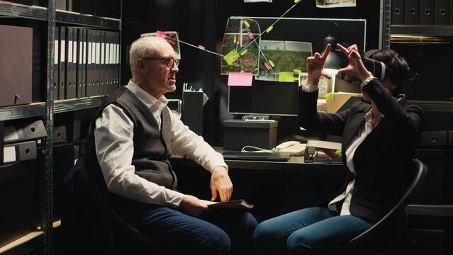 Detectives team reenacting crime scene with virtual reality glasses, using vr headset to recreate culprits actions for incriminating proof. Two police officers undertaking investigation.