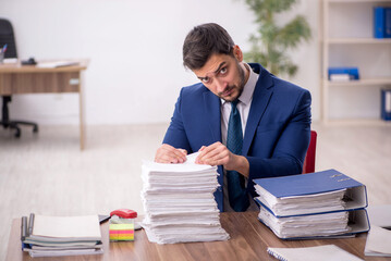 Young male employee and too much work in the office