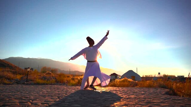 Dervish dance performed against the backdrop of nomads' yurts at sunset