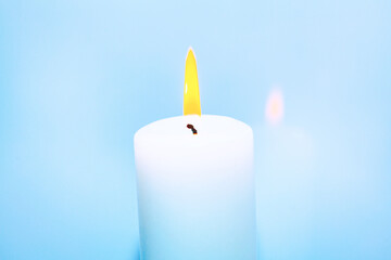 Burning candle at bright background . One white candle burning  