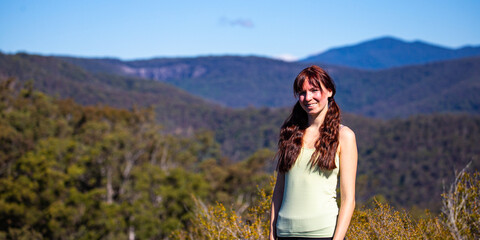 Portrait of beautiful girl  standing on the Pages Pinnacle ridge and enjoying the view. Hidden gems in Springbrook National Park, Gold Coast, Queensland 