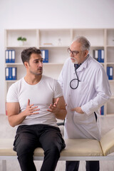 Fototapeta premium Young male patient visiting old male doctor