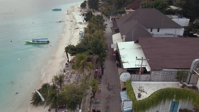 Aerial view of a street in  a beach town next to the ocean in Gilli Trawangan