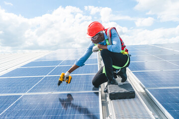 Male professional engineer installing solar photovoltaic panel system, Electrician mounting blue solar module technology on power industrial factory roof, Alternative energy ecological technician job