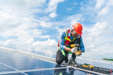 African American engineer maintaining solar cell panels on factory building rooftop. Technician...