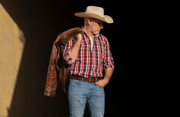 Portrait of adult man in cowboy hat against wall