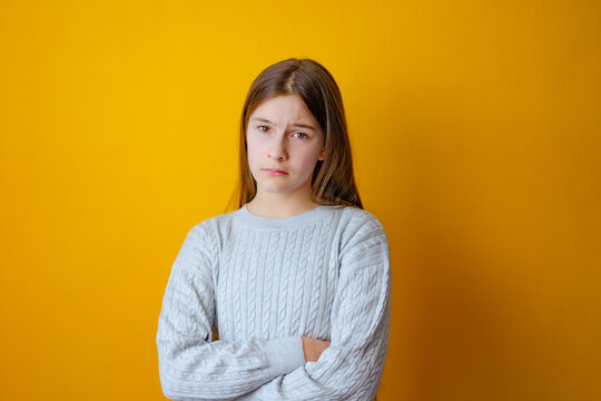 Serious Little Girl With Cross Arms On Chest And Look Determined