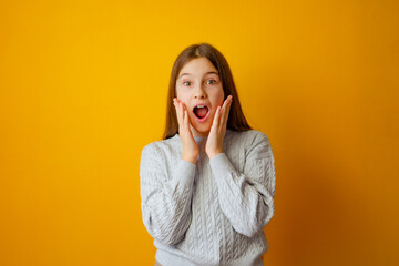 Cute little girl holding her hands near her open mouth in surprise