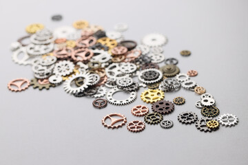 Pile of different size metal cogwheels on light grey table