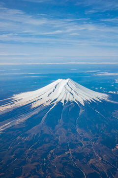 Top view of the Japan icon Mt Fuji from the airplane. Mt. Fuji seen from the window of an airplane. bird eye view of fuji mountain, famous volcano in japan, shot from airplane window.