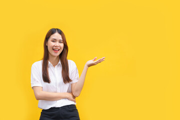 Women smiling and showing hand to presenting product with empty space on isolated yellow background