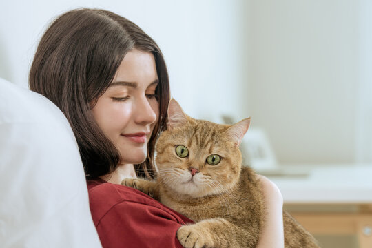 Young Asian Woman with Cat in Bedroom