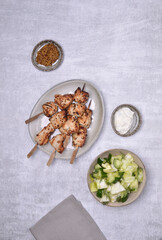 Fried slices of meat on wooden skewers.