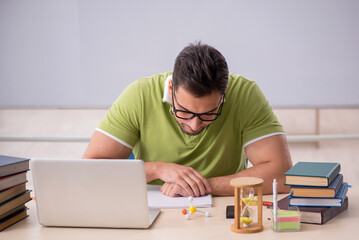 Young male student preparing for exams in the classroom